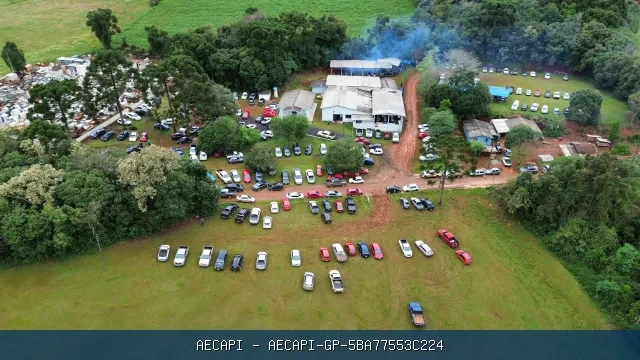 Fotografia aérea colorida mostrando a igreja, árvores, áreas de estacionamento e grande concentração de veículos e pessoas em uma festa na Comunidade Cantú Santa Rita. 
O evento aconteceu no domingo 13/09/2026. Costelada tradicional.